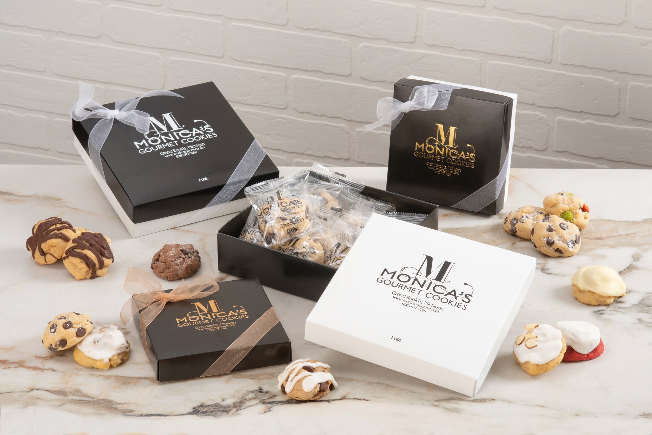 An arrangement of our gift boxes, used both for personal and corporate gifting, featuring our individually wrapped cookies: Iced Almond, Red Velvet, Peanut Butter Chocolate Delight, and Signature Chocolate Chip.