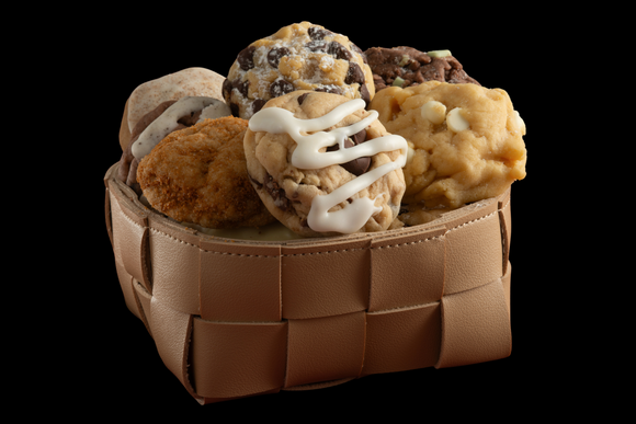 A leather basket featuring our handcrafted, gourmet Caramel Rock, White Chocolate Almond Macadamia, Chocolate Brownie Mint, Cookie Butter Bliss, and our Signature Chocolate Chip cookies.